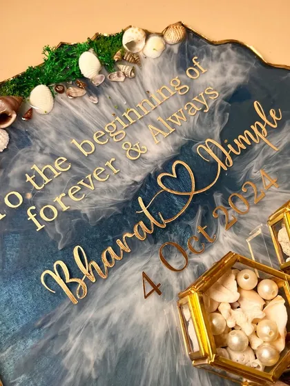 A close-up of the ocean-themed ring platter, showing the custom quote and the details of the shells and moss.