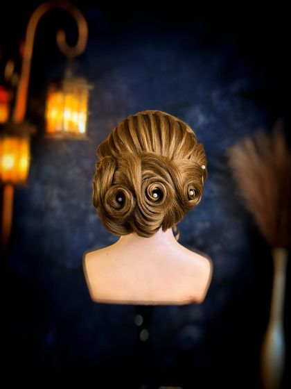 This elegant updo features perfectly formed swirls and pearl accents. We focus on precision and clean finishing to create polished and professional hairstyles.