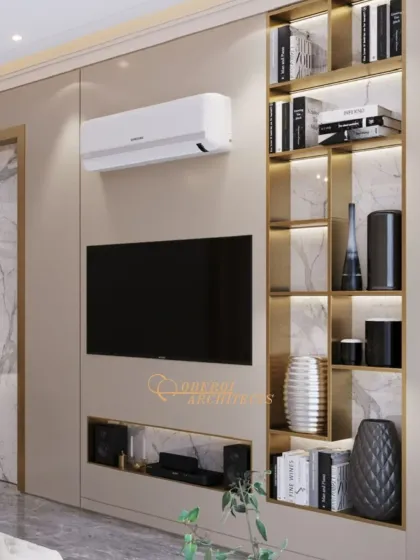 A close-up of the TV wall, featuring a backlit display shelf with brass accents that adds a touch of glamour and provides curated storage.