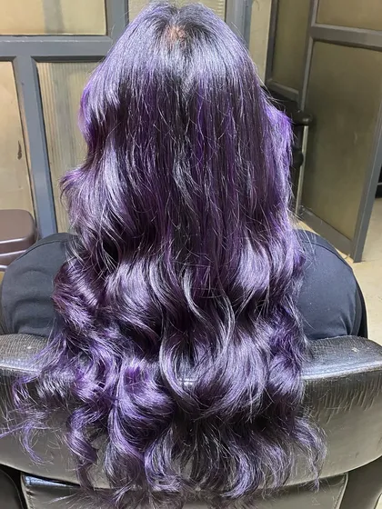 This vibrant purple balayage shows how we turn hair into a work of art. We use high-quality L'Oréal colors to create custom looks that are both bold and beautiful, styled into soft waves to show off the dimension.