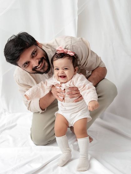 A father encouraging his baby to take a few steps. The baby's excited expression is priceless.