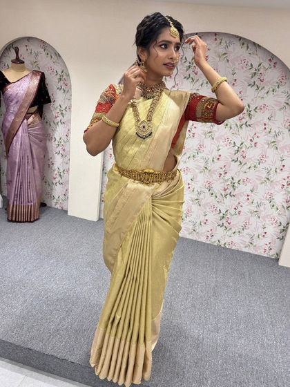 A model showcasing a beautiful golden silk saree from a workshop. This classic look is perfect for brides who want a timeless and regal appearance on their wedding day.