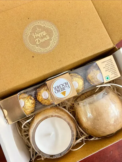 This thoughtful mini hamper is a perfect Diwali gift. It contains a set of two scented candles in glass jars and a pack of Ferrero Rocher chocolates.