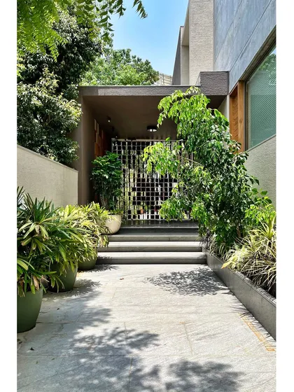 The arrival at the House of Terraces is a carefully choreographed experience. I designed this layered entry sequence with a sculpted screen and lush planters to soften the threshold, creating a gentle transition from the outside world into the private, tranquil spaces within.