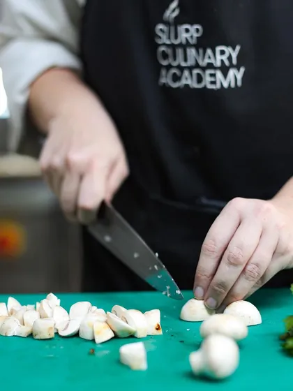 Perfecting knife skills. A student practices dicing mushrooms, a core competency taught in the first week of our pre-professional course.