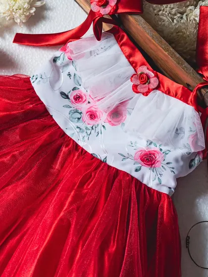 Another angle of the red and white floral dress, showing the delicate construction of the bodice and the richness of the red tulle skirt.
