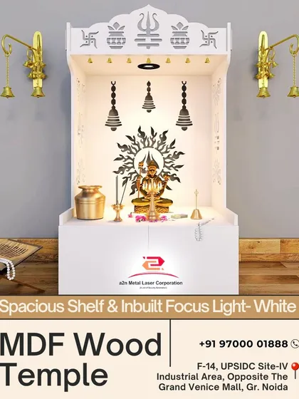 This white MDF wood temple is designed for modern homes, featuring inbuilt focus lights and laser-cut religious symbols on top. The clean design includes hanging bell motifs on the back panel and provides a spacious shelf for idols and prayer items.