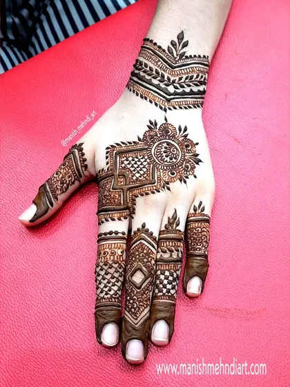 A modern geometric design for the back of the hand. The sharp lines and structured patterns offer a contemporary alternative to traditional floral mehndi.