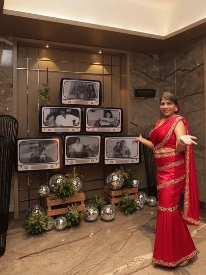 A unique photo wall featuring old family pictures displayed on vintage TV set props, celebrating the birthday girl's life story.