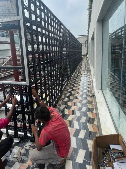 Our installers meticulously attach each section of the vertical garden frame along a long corridor.