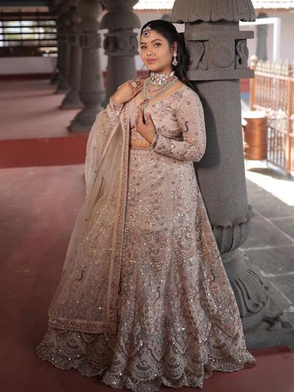 This pose highlights the beautiful fall of the lehenga skirt and the detailed embroidery on the full sleeved blouse.