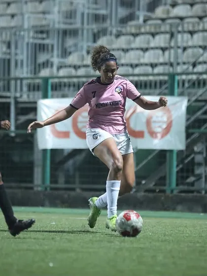 A player dribbling at speed, taking on a defender during an intense match.