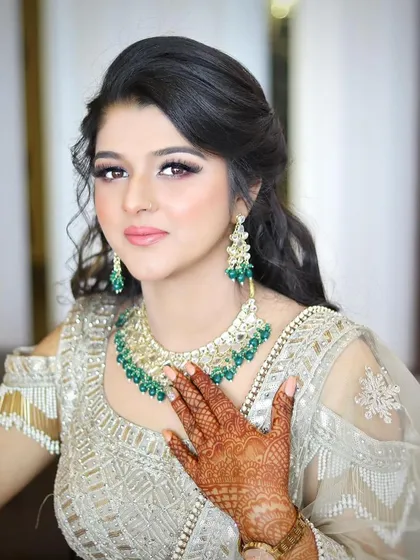 An elegant engagement or reception look. The soft, side-parted hairstyle and glowing makeup are perfect for a modern bride.