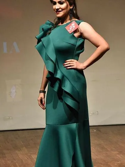 A client confidently walks the stage in the green ruffle gown. The dress's structure and vibrant color ensure you'll stand out in any crowd.