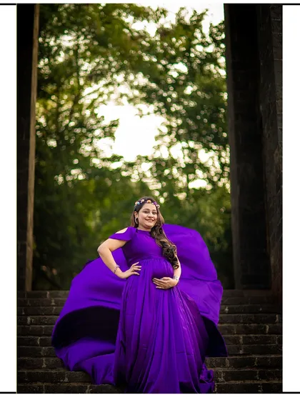 This rich purple gown with a flowing train makes for a truly majestic portrait. The vibrant color stands out beautifully against natural and architectural backdrops.