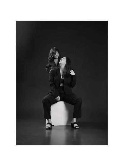 The contrast in this black and white photo is striking. A mother and daughter's shared laughter is captured with a dramatic, high-fashion feel, showing the modern side of family portraits.