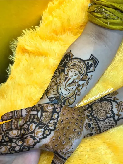 A powerful portrait of Lord Ganesha on the forearm, paired with a peacock feather design on the hand. This shows how we can combine different elements into one cohesive piece.