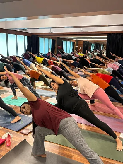 Students in Utthita Parsvakonasana during a packed community class. The focus and alignment in the room are inspiring to see.
