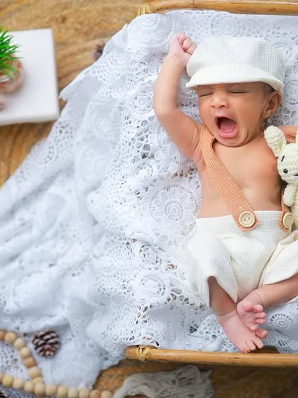 Another adorable yawn, this time with a little cap and a stuffed bunny. These small additions to the setup add a touch of whimsy to the portrait.