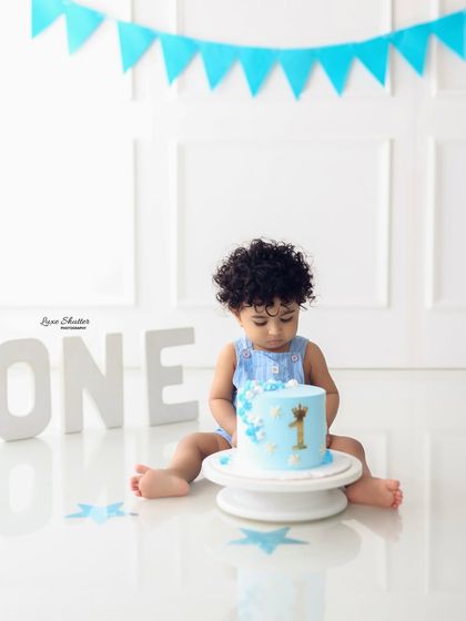 Getting his hands messy! The cake smash is all about capturing the fun and sensory experience for the baby.