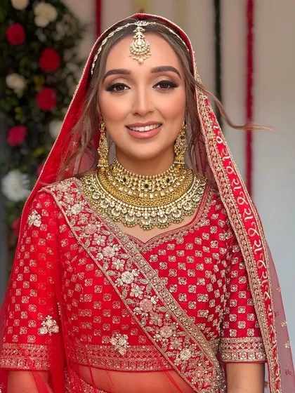 A close-up of the bride with her dupatta set. The hairstyle is visible underneath, adding softness to the overall look.
