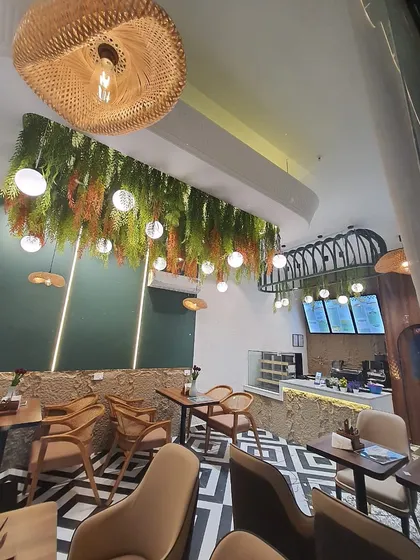 Another view of the cafe's hanging garden ceiling, showing how it complements the natural textures and modern design of the space.