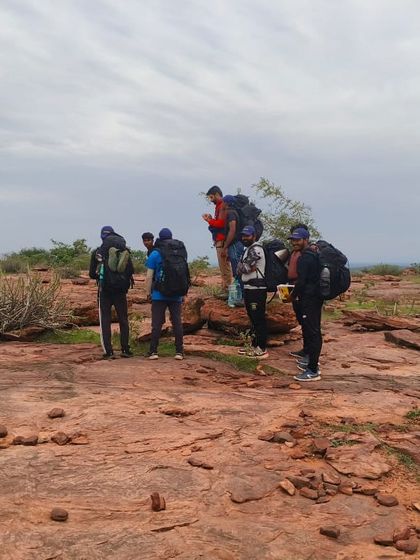 A team of climbers with large backpacks prepares for a multi-day climbing expedition.