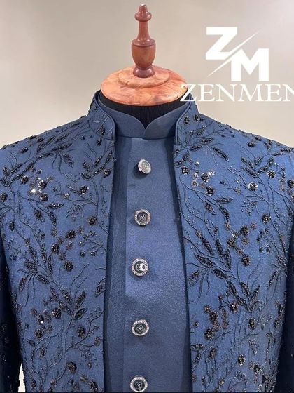 A close-up of a stunning blue Indo-Western jacket with all-over black floral beadwork. The texture and craftsmanship are exceptional.