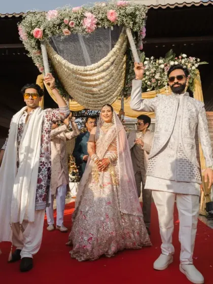 The bride's grand entrance under the phoolon ki chaadar, a moment filled with tradition and emotion. Her serene expression shows she's ready to meet her groom at the mandap.