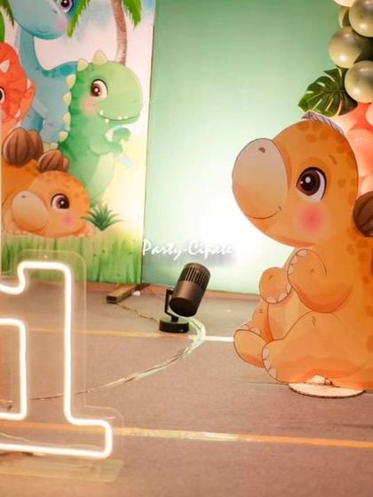 A neon light-up number '1' and a cute dinosaur cutout. I love using different lighting elements to make the decor pop.