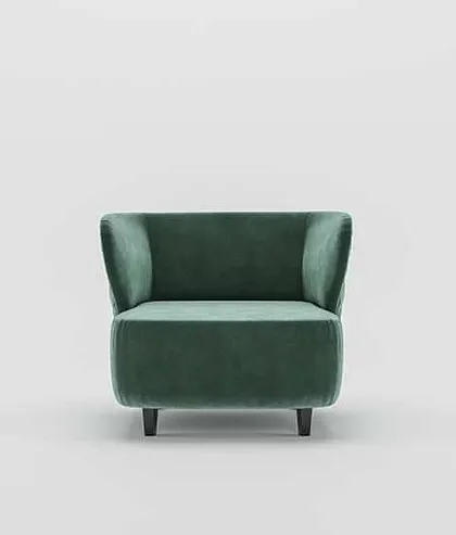 A front view of the green velvet armchair, showing its simple, elegant form and invitingly plush seat.