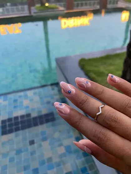 A beautiful shot of these evil eye nails by the pool. The design is subtle yet so stylish.