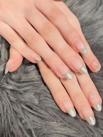 For a touch of sparkle, I offer glitter French tips. This set features a beautiful silver glitter tip on natural-looking extensions.
