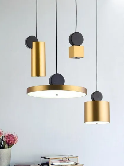 This collection of geometric pendants can be mixed and matched to create a custom lighting arrangement. Featuring cylinders, discs, and cubes in a brushed gold and black finish, they are perfect for a modern, eclectic interior.