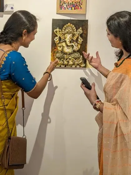 Two visitors discussing my 'Panchaloha Ganesha' painting. I love seeing my art spark conversations.