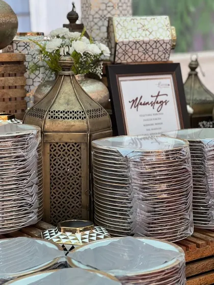 A beautifully arranged main course station, with elegant lanterns and gold-rimmed plates ready for guests.