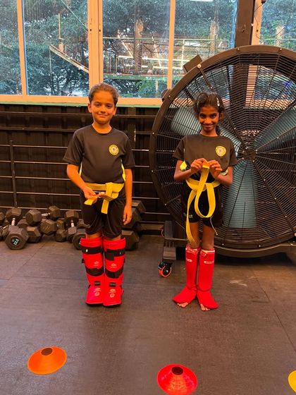 Two of our junior students proudly showing off their new grading tags on their yellow belts.