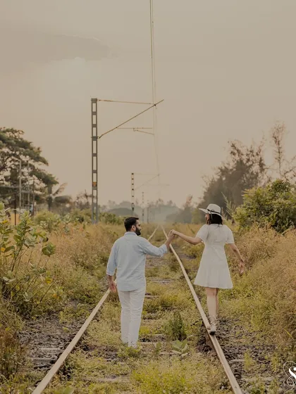 Walking the tracks of life together. This playful shot on an old railway line symbolizes the start of a new journey, hand in hand, with a sense of adventure.