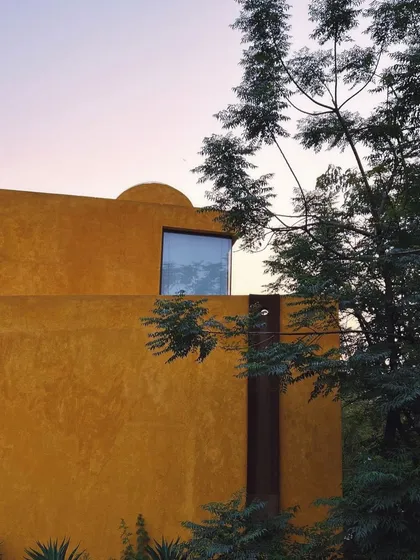 A window reflects the dusk sky, blurring the boundary between the interior and the world outside.