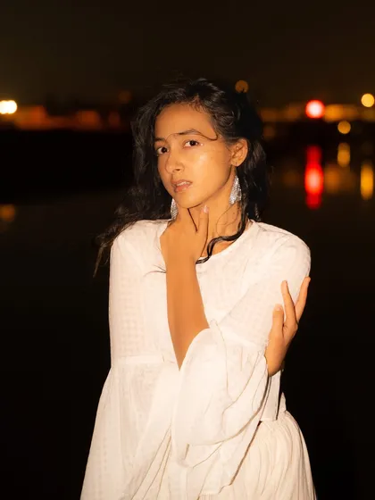 A night beach shoot with a completely different feel. The all-white outfit glows against the dark background, creating an ethereal, almost magical look.