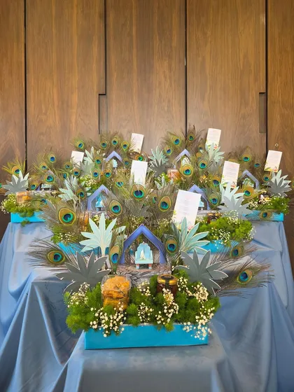 A shot of the themed hampers against a clean, wood-paneled background, emphasizing the vibrant colors and intricate details of the "Little Kanha" design.