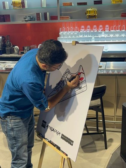 An event attendee participates in our collaborative art activity, adding his own drawing to the large sneaker canvas. This interactive element is always a huge hit with guests of all ages.