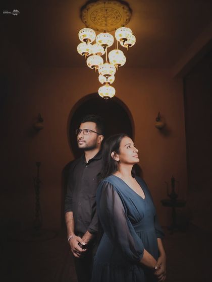 A dramatic portrait using a single, ornate chandelier to create a moody and artistic feel. This style of photography is perfect for couples looking for something unique and striking.