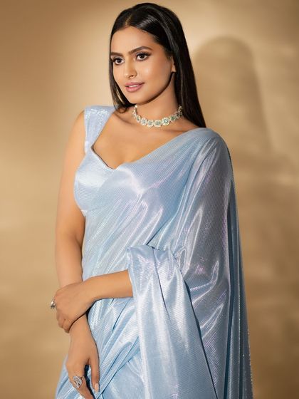 A side profile of the client, showcasing her elegant hairstyle and the beautiful sheen of her saree.