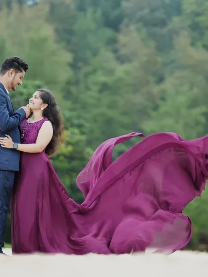 An intimate pre-wedding portrait with a flowing purple trail gown. The movement of the fabric adds a beautiful, artistic element to the photo.