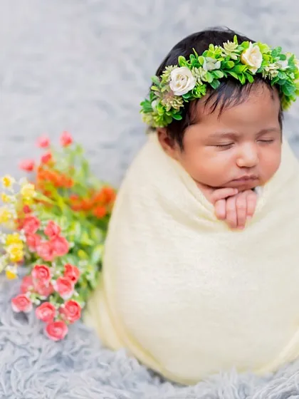 A cozy swaddle is perfect for keeping a baby calm and comfortable. Here, I paired a simple cream wrap with a fresh green floral crown and a small bouquet to add a touch of natural color.