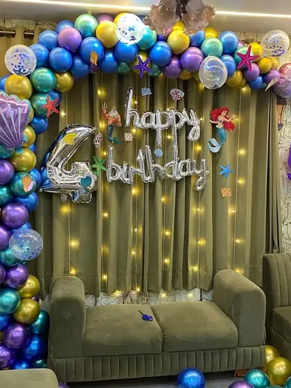The full mermaid-themed backdrop, set against a curtain with fairy lights to create a sparkling water effect.