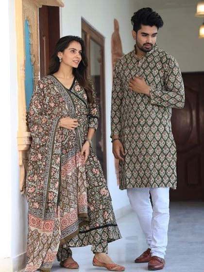 An earthy olive green couple set with delicate floral block prints. The woman's Anarkali is detailed with a contrasting border, matching the intricate pattern of the men's kurta.