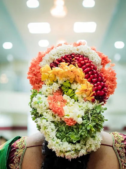 A close-up of the intricate and colorful fresh flowers adorning a mother-to-be's hair during her baby shower. We pay attention to the beautiful cultural details that make your celebration unique.