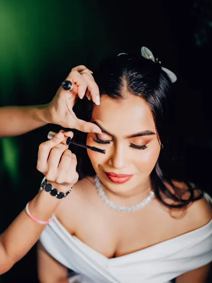 The final touch of mascara to make the eyes pop. This close-up shot captures the detail that goes into every single step of the makeup application.